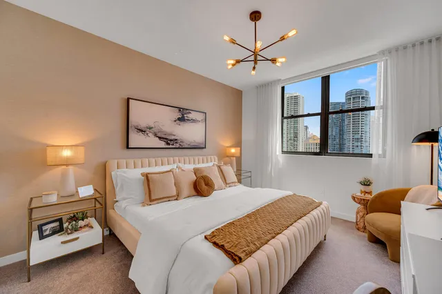 a bedroom with a large bed and a chandelier