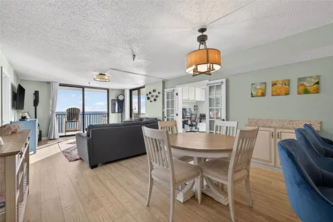 a dining room with wooden floor and large windows