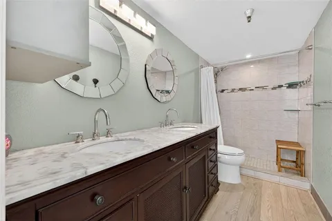 a bathroom with a granite countertop sink a toilet and a mirror