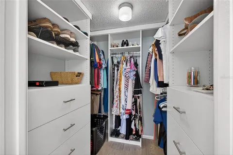 a view of walk in closet with clothes and shoes