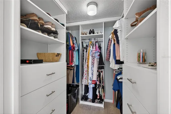 a view of walk in closet with clothes and shoes