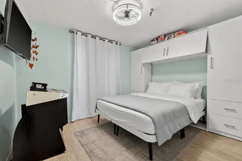 a bedroom with a bed and a flat tv screen on the dresser