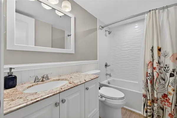 a bathroom with a granite countertop sink toilet and shower