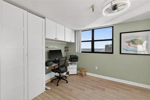 a view of a workspace with furniture and a window
