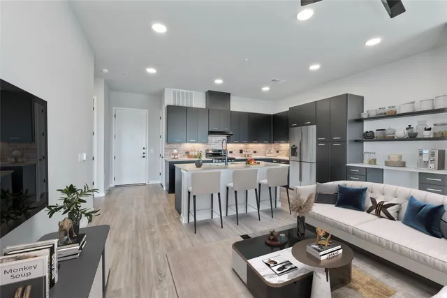 a living room with furniture and a dining table with kitchen view