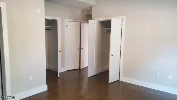 an empty room with wooden floor and a bathroom