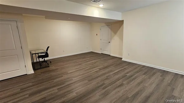 a view of room with wooden floor and bench