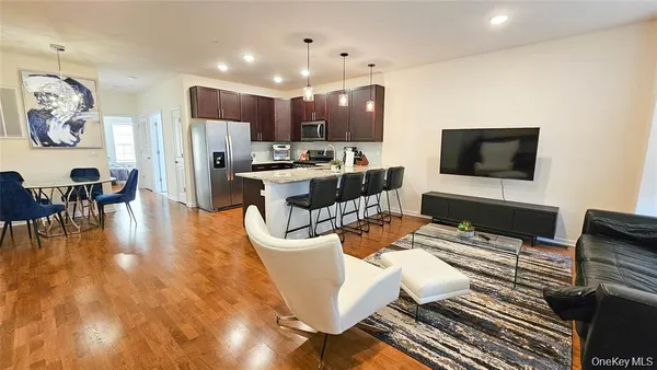 a living room with furniture kitchen view and a flat screen tv