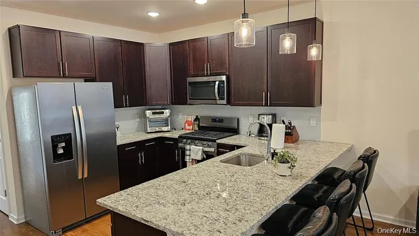 a kitchen with stainless steel appliances granite countertop a refrigerator stove a sink and dishwasher