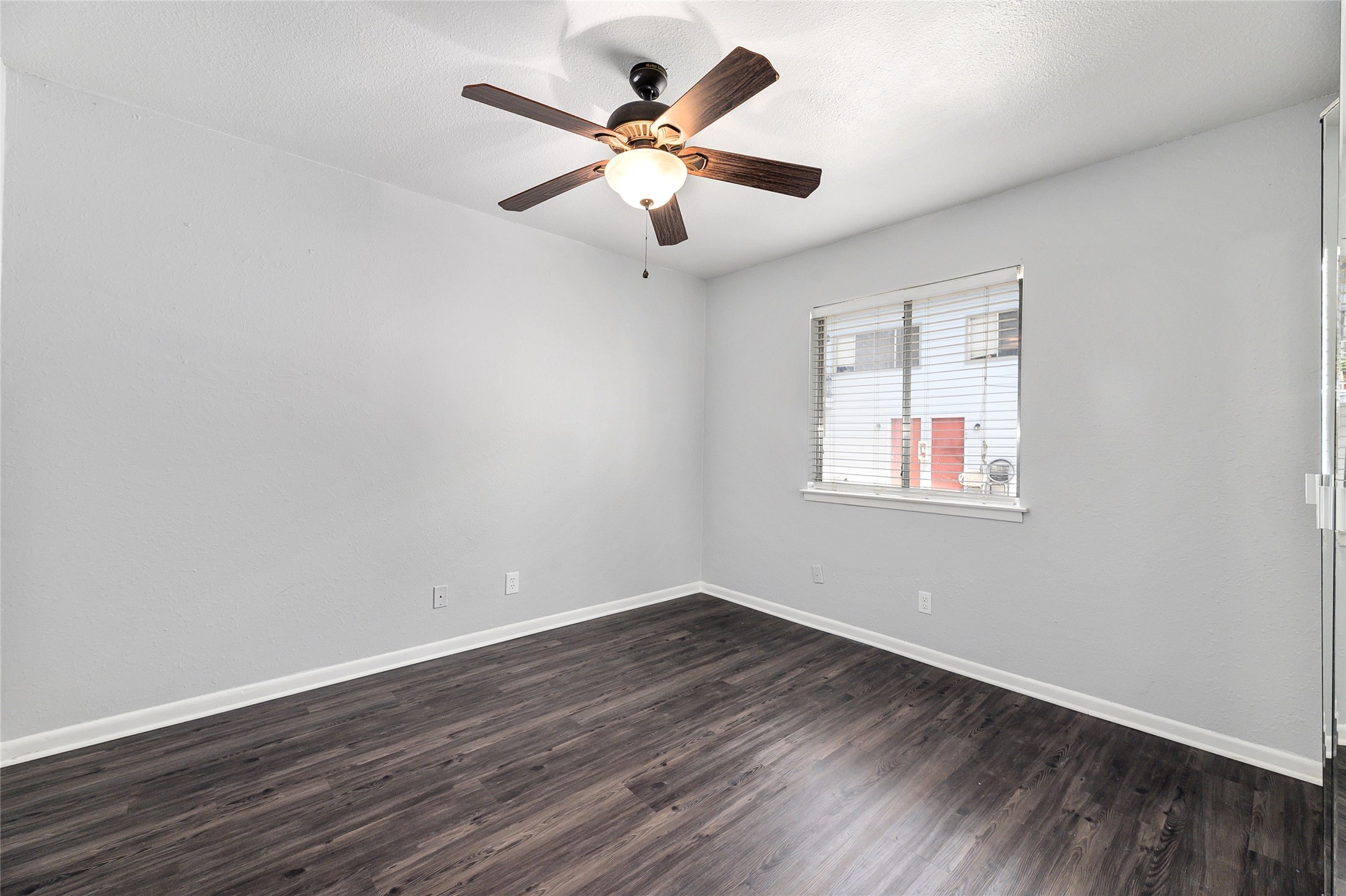 2408 Longview Street, Unit 113 Austin, TX 78705 - Photo 13 of 23 Spare room with dark wood finished floors, a ceiling fan, and a textured ceiling