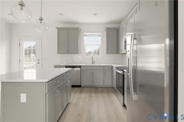 a kitchen with a sink refrigerator and cabinets