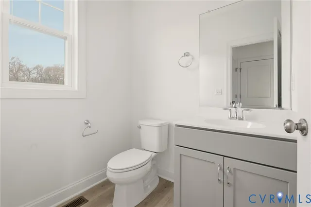 a bathroom with a toilet a sink a vanity and mirror