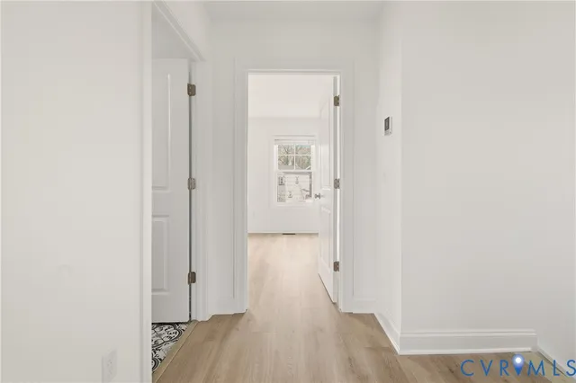 a view of a hallway with wooden floor