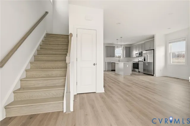 a view of a kitchen with wooden floor and electronic appliances
