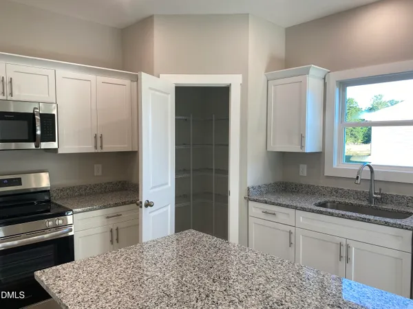 a kitchen with granite countertop a sink and a window