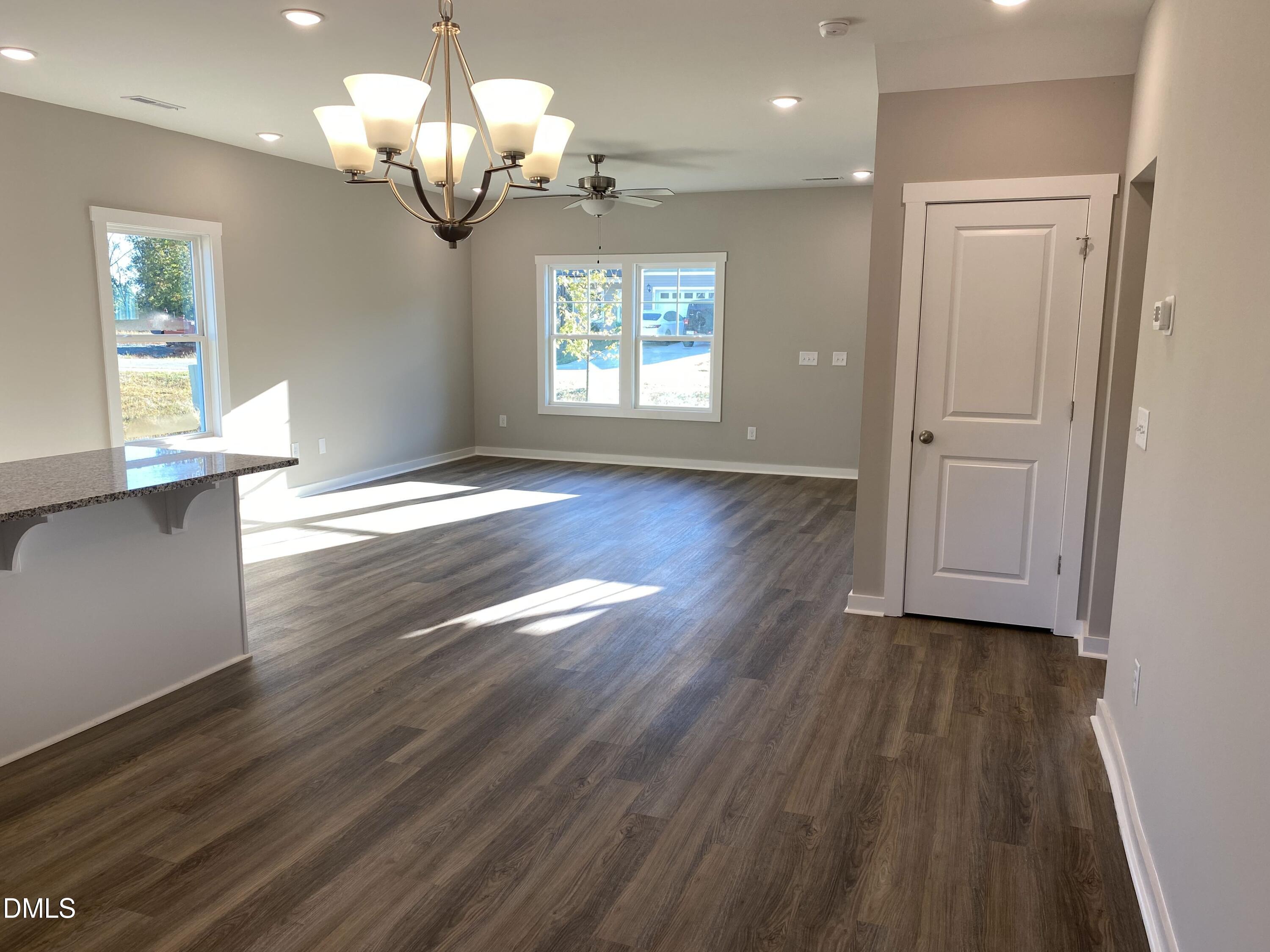2827 Ricolden Trail Elon, NC 27244 - Photo 11 of 30 an empty room with wooden floor chandelier and windows