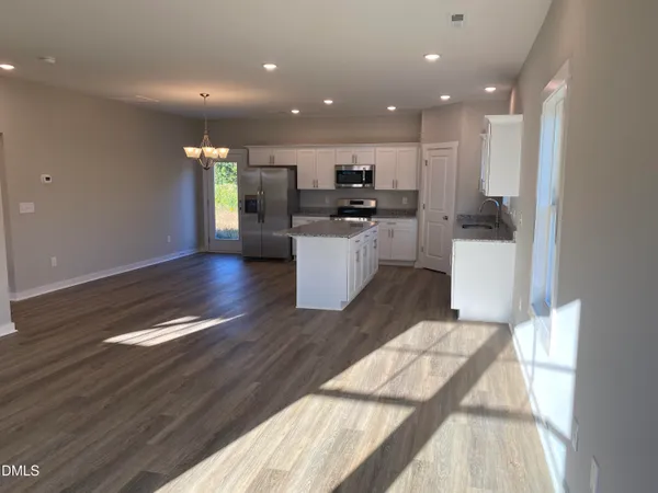 a kitchen with kitchen island granite countertop a sink a counter top space and cabinets