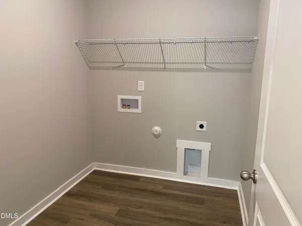an empty room with wooden floor chandelier and windows
