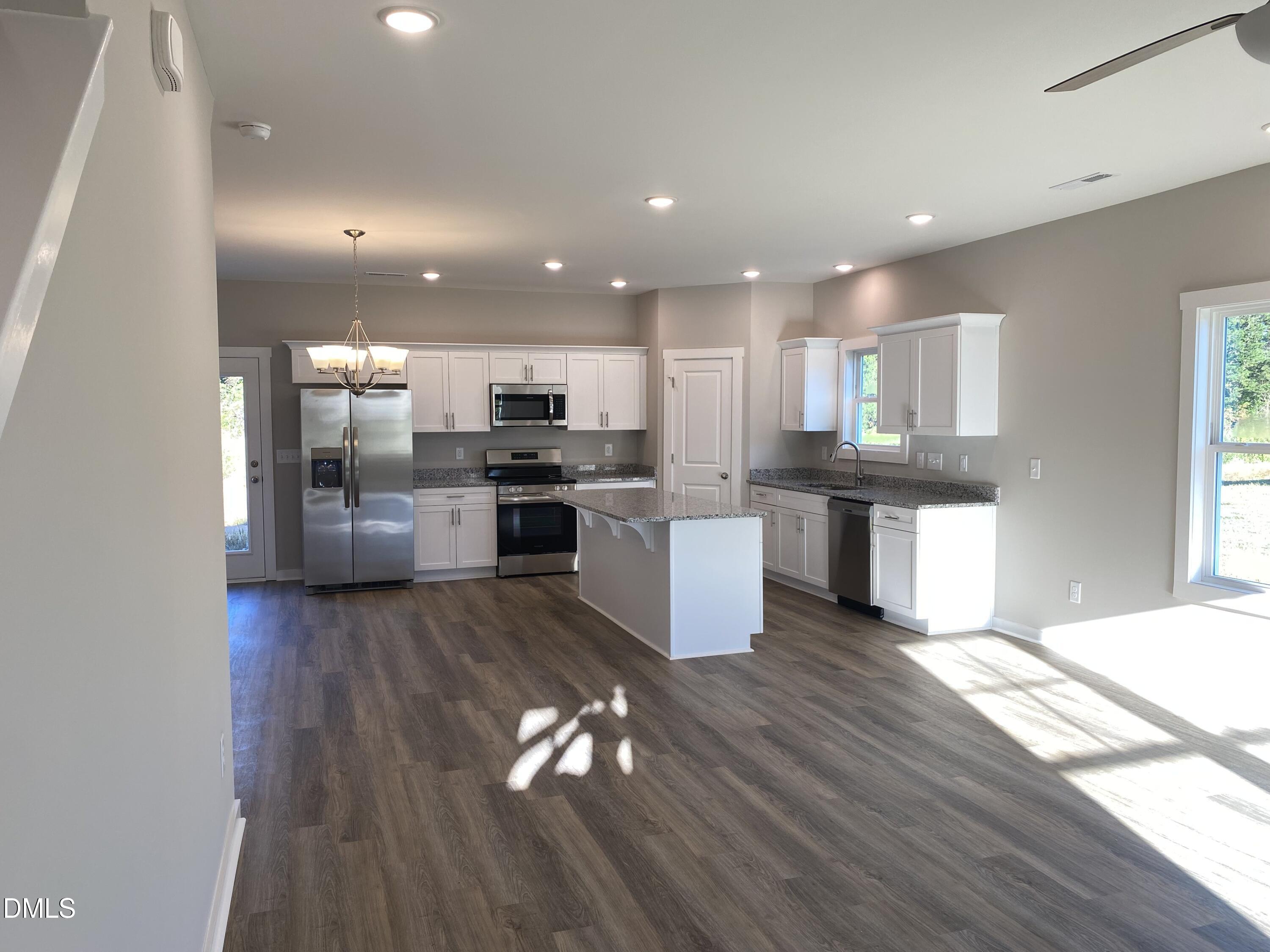 2827 Ricolden Trail Elon, NC 27244 - Photo 2 of 30 a kitchen with stainless steel appliances kitchen island granite countertop wooden floors and view living room