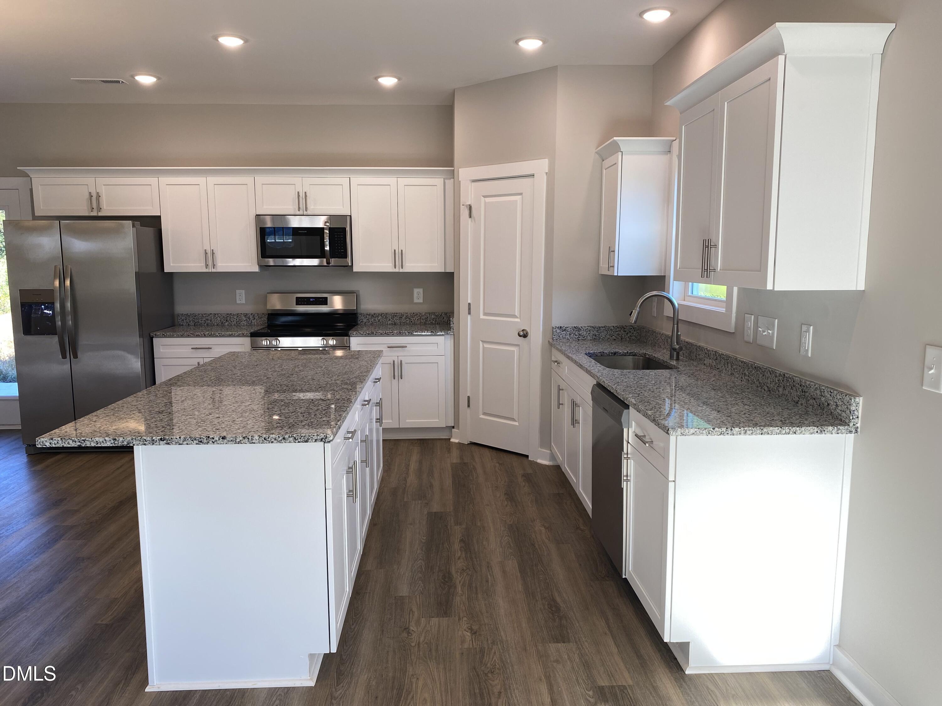 2827 Ricolden Trail Elon, NC 27244 - Photo 4 of 30 a kitchen with stainless steel appliances a sink stove and refrigerator