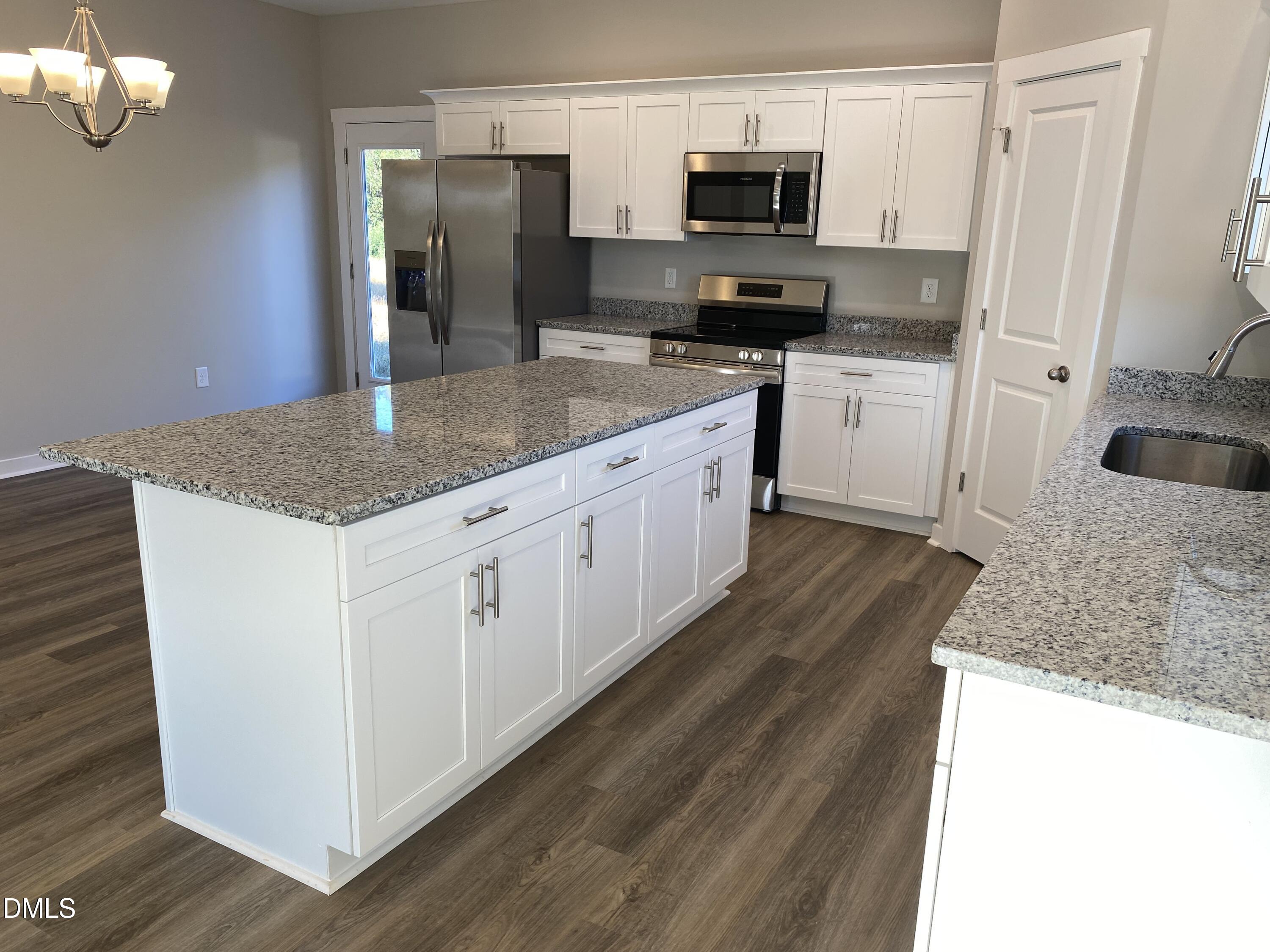 2827 Ricolden Trail Elon, NC 27244 - Photo 6 of 30 a kitchen with stainless steel appliances granite countertop a sink a microwave a refrigerator and white cabinets