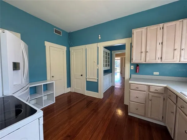 a kitchen with cabinets and wooden floor