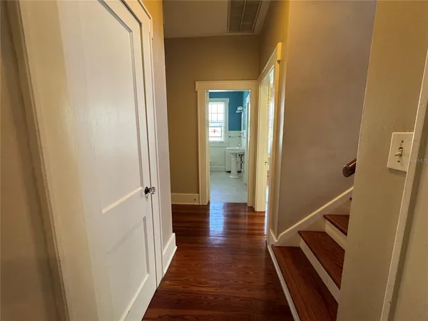 a view of a hallway with wooden floor and staircase