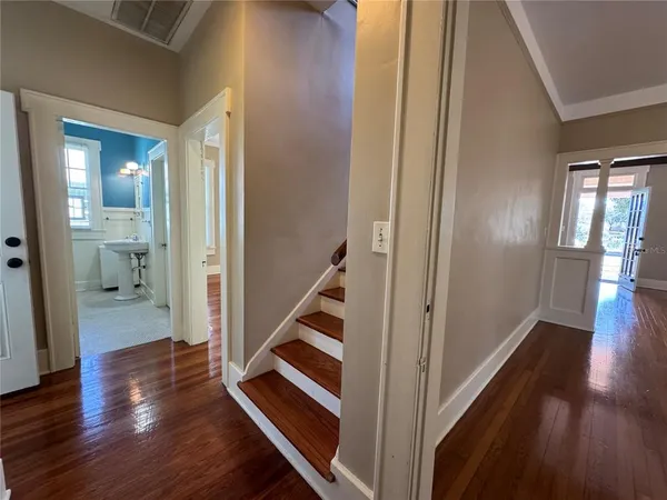 a view of a hallway with wooden floor and staircase