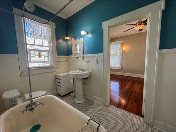 a bathroom with a sink and mirror with bathtub