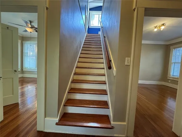 a view of a hallway with wooden floor and entryway