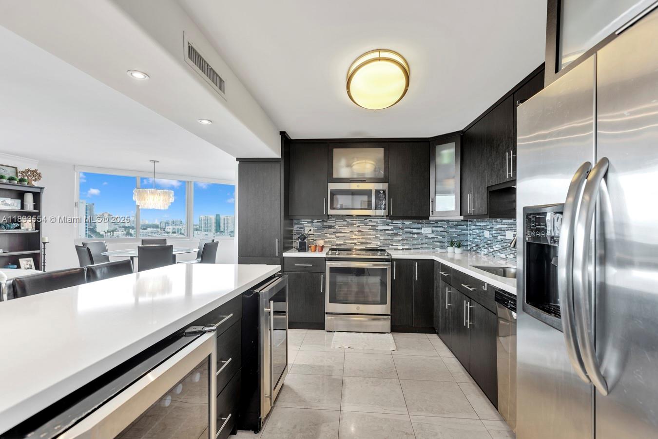 7135 Collins Avenue, Unit 1126 Miami Beach, FL 33141 - Photo 11 of 45 a large kitchen with stainless steel appliances granite countertop a stove and a sink