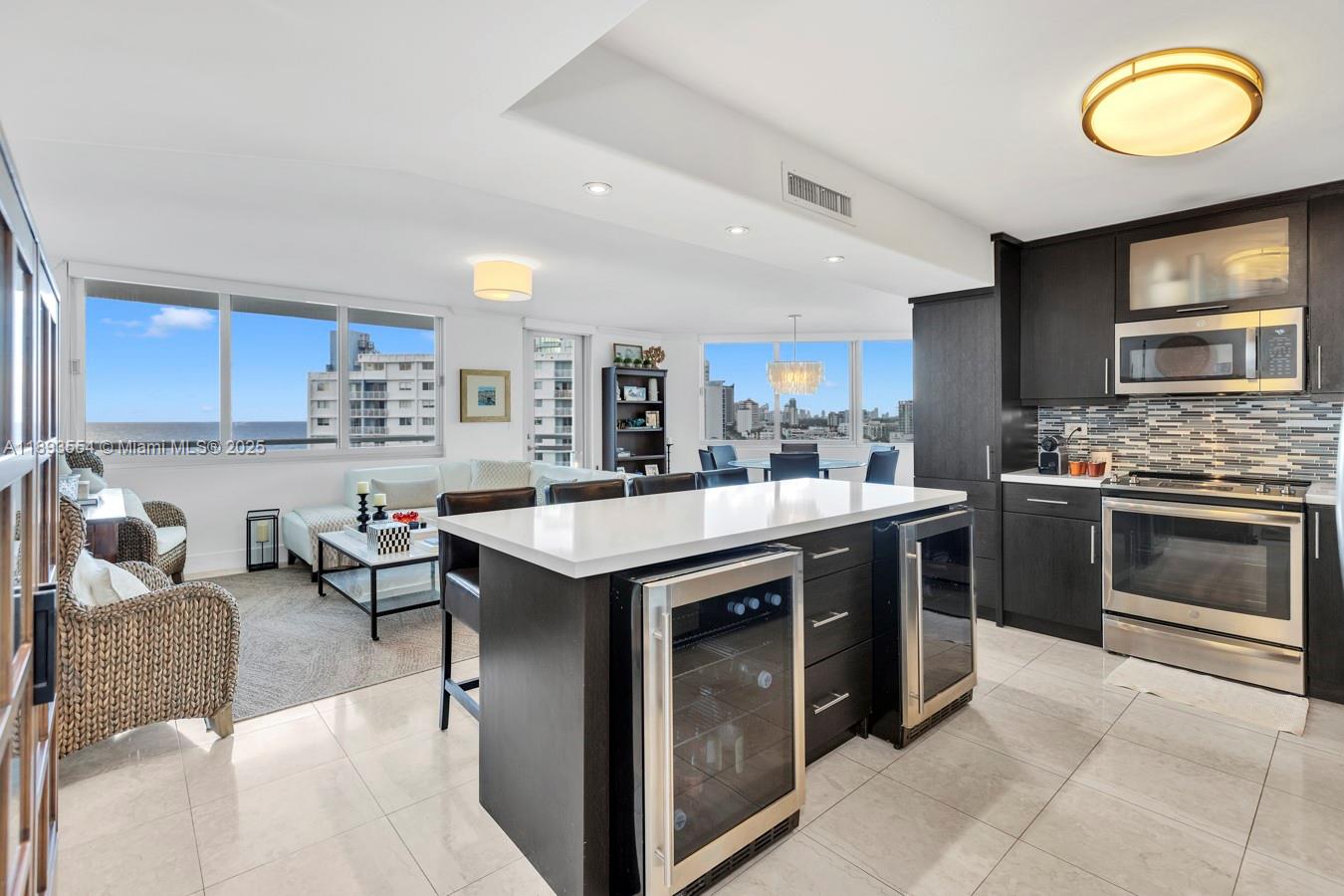 7135 Collins Avenue, Unit 1126 Miami Beach, FL 33141 - Photo 12 of 45 a kitchen with stainless steel appliances granite countertop a stove top oven a sink dishwasher and cabinets