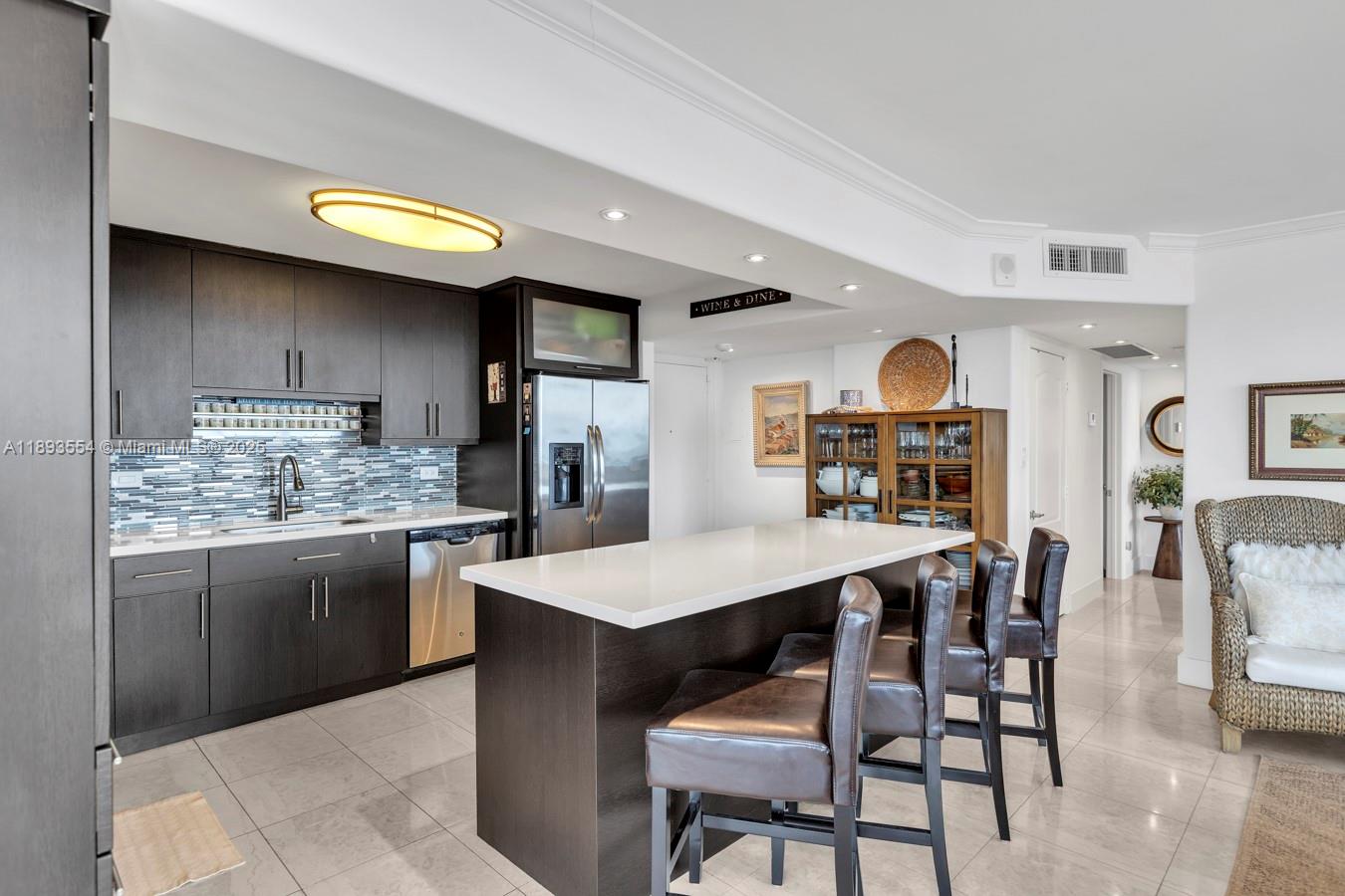 7135 Collins Avenue, Unit 1126 Miami Beach, FL 33141 - Photo 13 of 45 a kitchen with stainless steel appliances granite countertop a kitchen island a stove a table and chairs