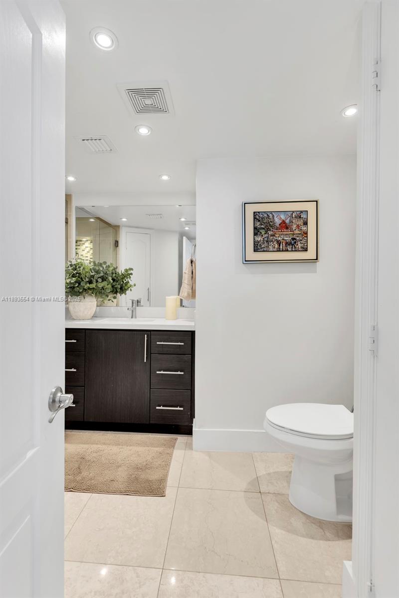 7135 Collins Avenue, Unit 1126 Miami Beach, FL 33141 - Photo 16 of 45 a bathroom with a toilet a sink and mirror