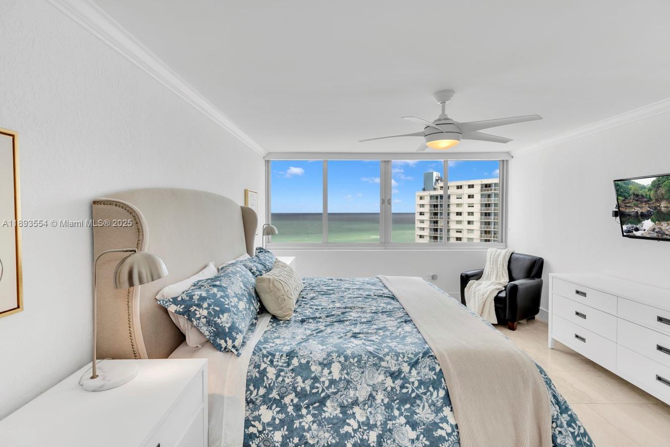 7135 Collins Avenue, Unit 1126 Miami Beach, FL 33141 - Photo 19 of 45 a bedroom with a bed and a chandelier