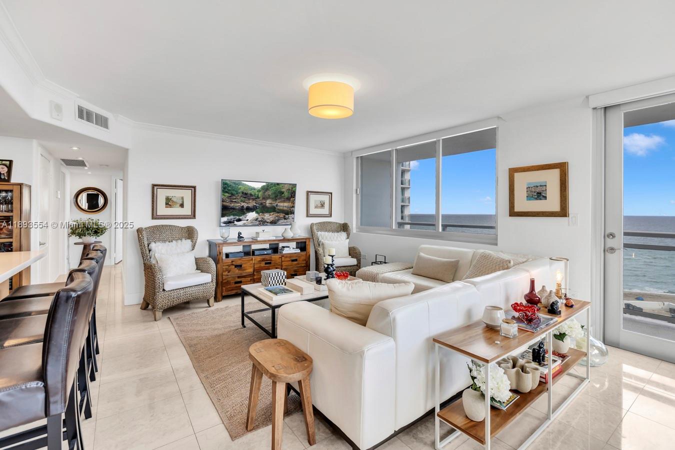 7135 Collins Avenue, Unit 1126 Miami Beach, FL 33141 - Photo 2 of 45 a living room with furniture and a flat screen tv