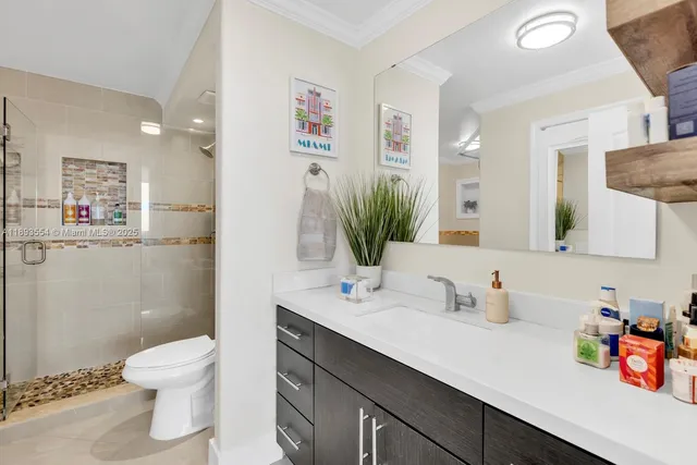 a bathroom with a sink a toilet and shower