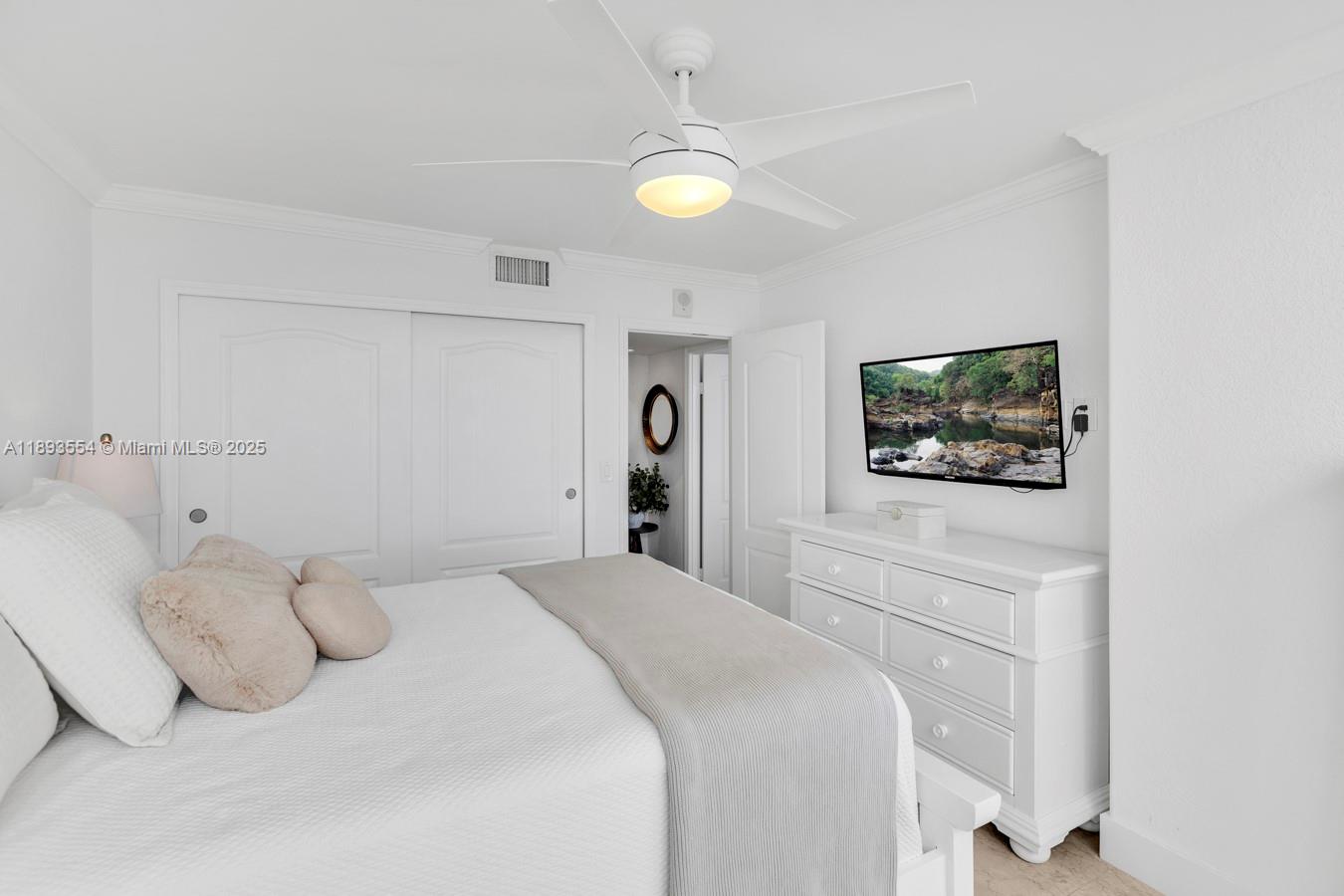 7135 Collins Avenue, Unit 1126 Miami Beach, FL 33141 - Photo 26 of 45 a bedroom with a bed and a chandelier
