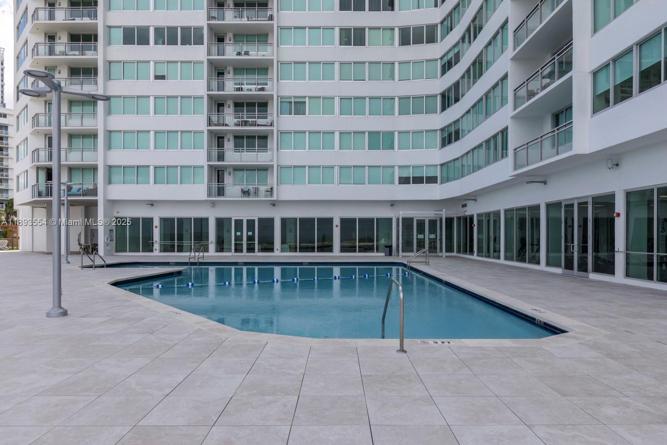 7135 Collins Avenue, Unit 1126 Miami Beach, FL 33141 - Photo 28 of 45 a view of a swimming pool with a chairs