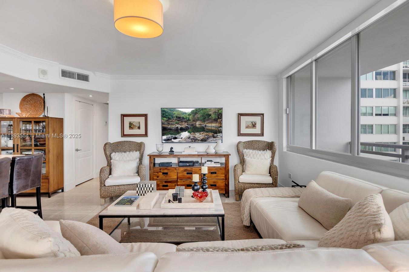 7135 Collins Avenue, Unit 1126 Miami Beach, FL 33141 - Photo 3 of 45 a living room with furniture and a flat screen tv