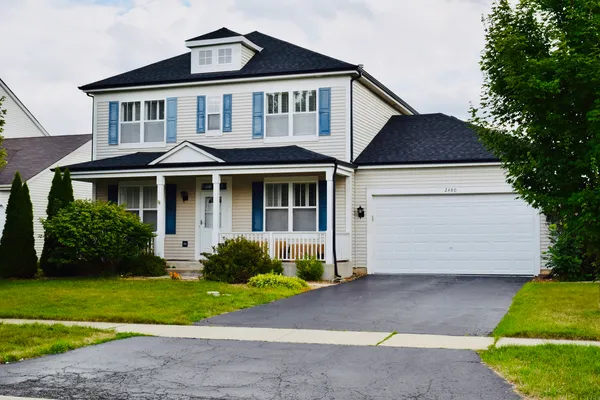 a front view of a house with a yard and garden