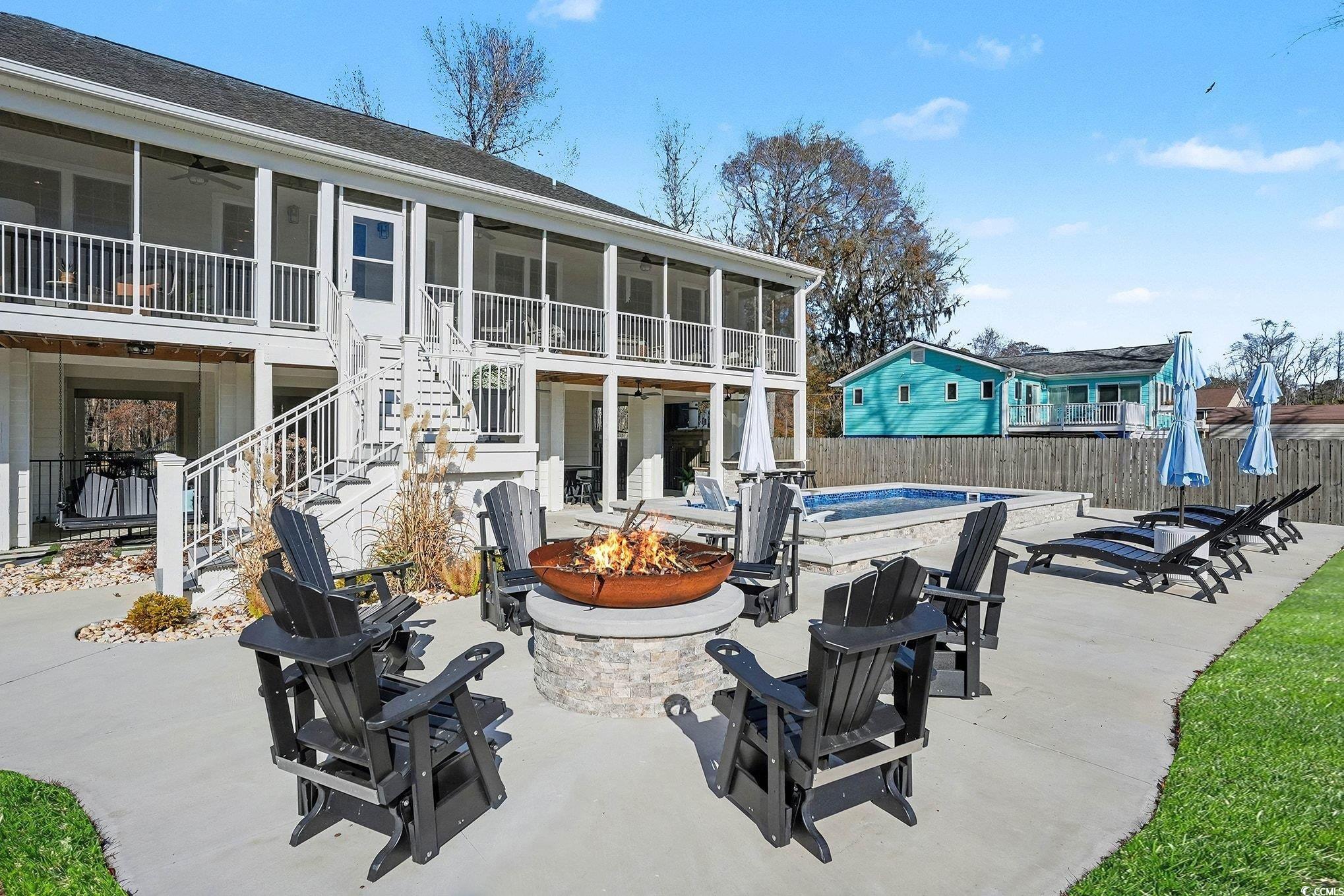 3741 Ed Smith Avenue Myrtle Beach, SC 29588 - Photo 30 of 38 Rear view of house featuring a fire pit, ceiling fan, a patio area, stairs, and a sunroom