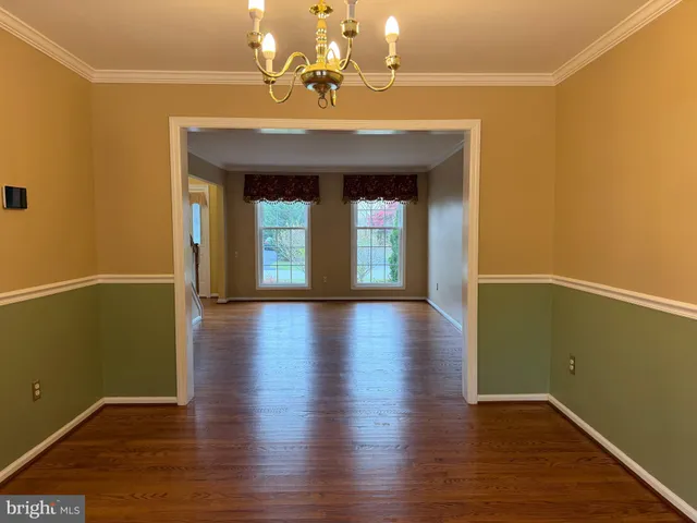 a view of a room with wooden floor and chandelier