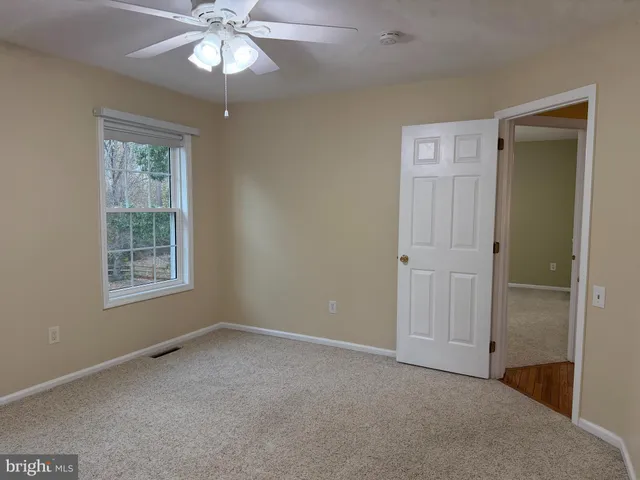 an empty room with a window and a fan