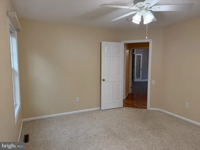 an empty room with a chandelier fan