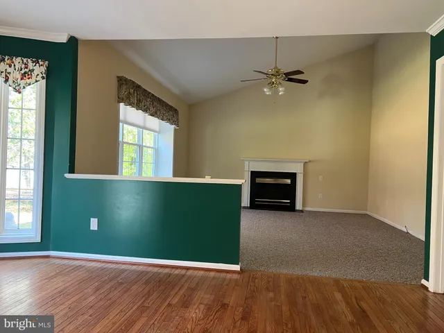 an empty room with a fireplace and windows
