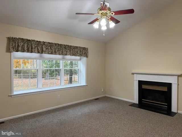an empty room with windows and fireplace
