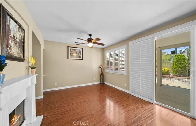 a kitchen with a refrigerator a stove and white cabinets with wooden floor