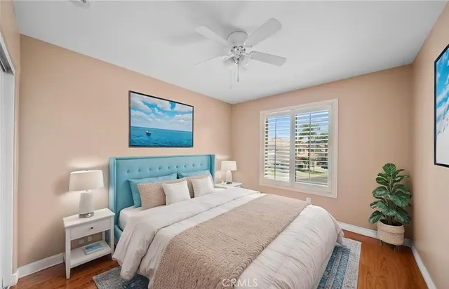 a view of empty room with wooden floor and fan