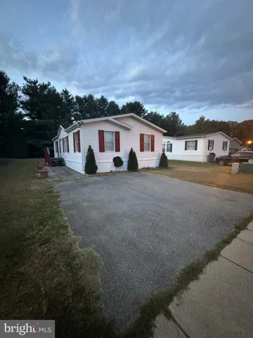 a view of a house with a yard and large trees